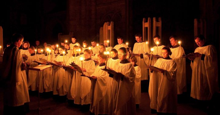 The choir of Durham Cathedral singing by candle light at a traditional Christmas carol service